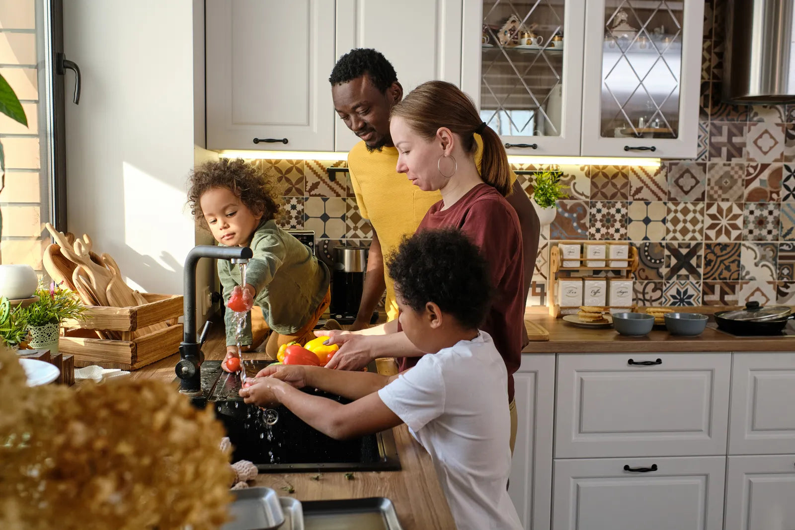 Family washing produce at kitchen faucet, enjoying clean, filtered water from a 400 or 600 GPD reverse osmosis system.