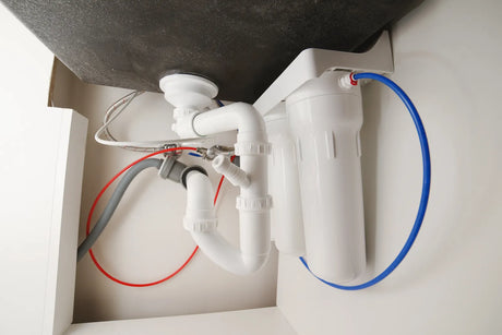 Close-up view of finished plumbing pipework for a compact under-sink RO unit, revealing material outlays counted inside the full one-time RO system installation cost.