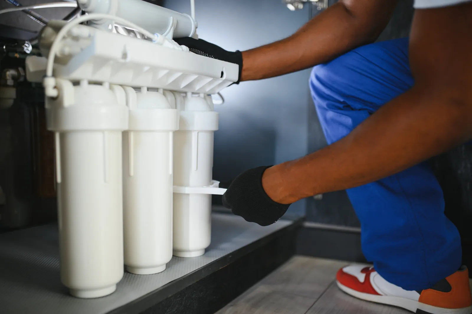 Technician inspecting an under sink RO filter system during maintenance