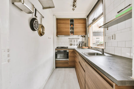 A compact tiny home kitchen with narrow cabinetry, ideal for space-saving under-sink water filters.