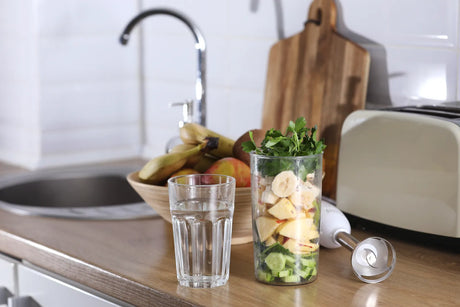 Glass of clean water next to a jar of fresh organic produce, emphasizing the use of pure water in preparing organic meals.