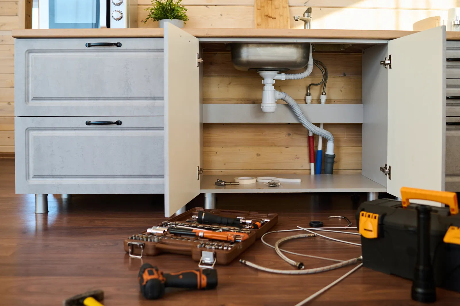 Empty under-sink area in a kitchen, showing the ideal space to install a compact reverse osmosis water filter system.