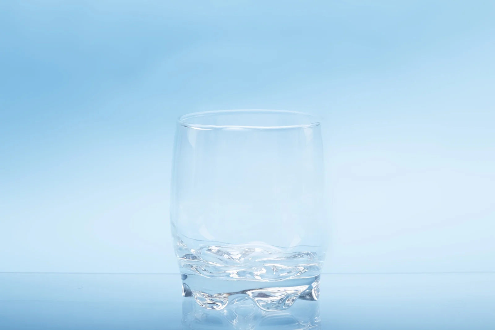 Clear glass of water on light blue background, showing nitrates in drinking water are invisible and undetectable to the eye.