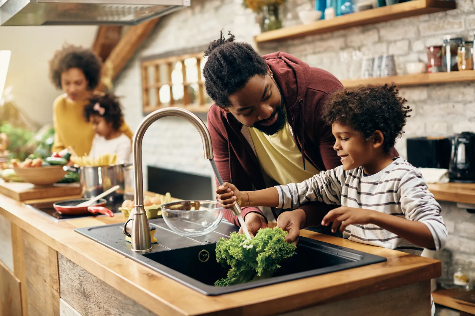 A large family washes fresh vegetables together in the kitchen using pure RO water.