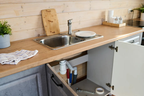 Tools sit ready beneath a kitchen sink for eco-friendly tankless RO filter installation.